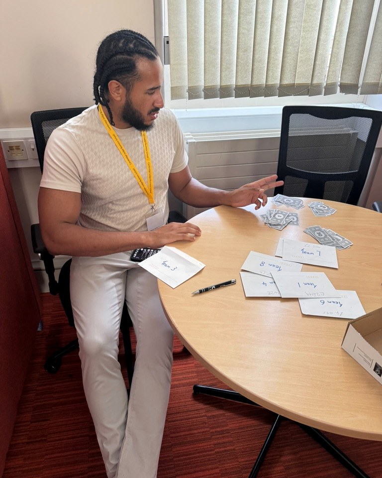 Devon working through options with cards and notes at a table.